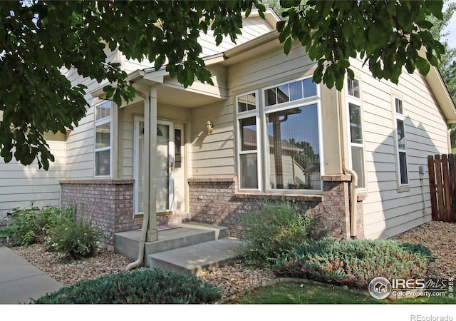 entrance to property featuring brick siding