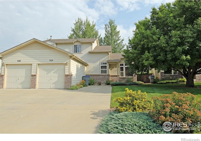 view of front of home featuring driveway, brick siding, an attached garage, and a front yard