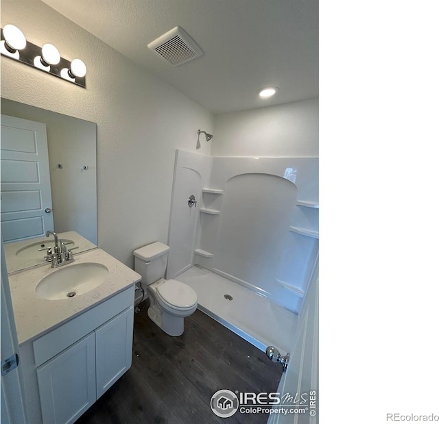 full bathroom featuring toilet, visible vents, walk in shower, and wood finished floors