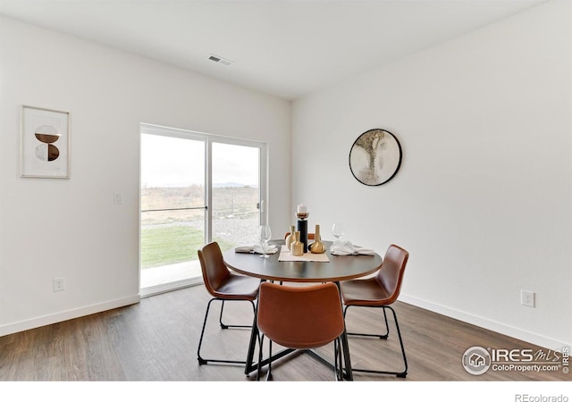 dining room featuring baseboards, visible vents, and dark wood-type flooring