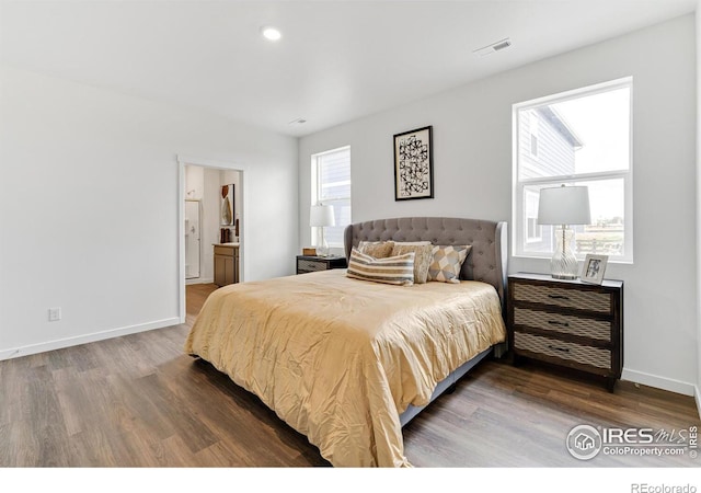 bedroom with visible vents, dark wood finished floors, and baseboards