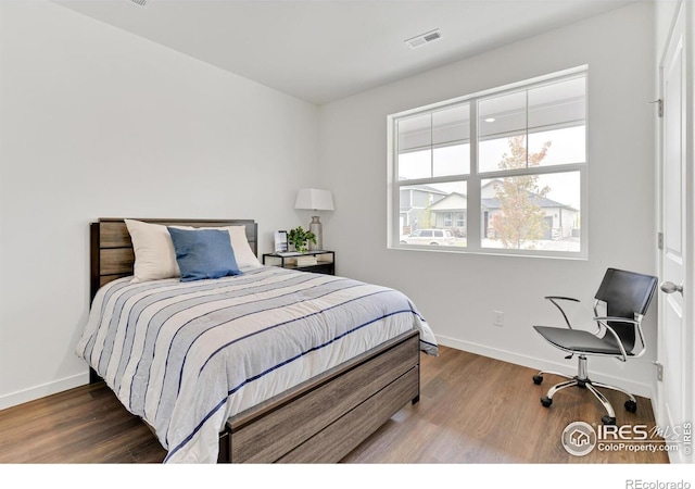 bedroom featuring dark wood-style floors, visible vents, and baseboards