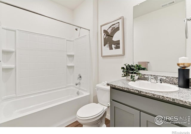 bathroom with visible vents, toilet, wood finished floors, vanity, and washtub / shower combination