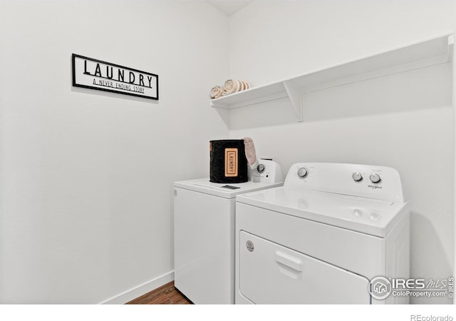 laundry area with dark wood-style flooring, laundry area, baseboards, and washing machine and clothes dryer