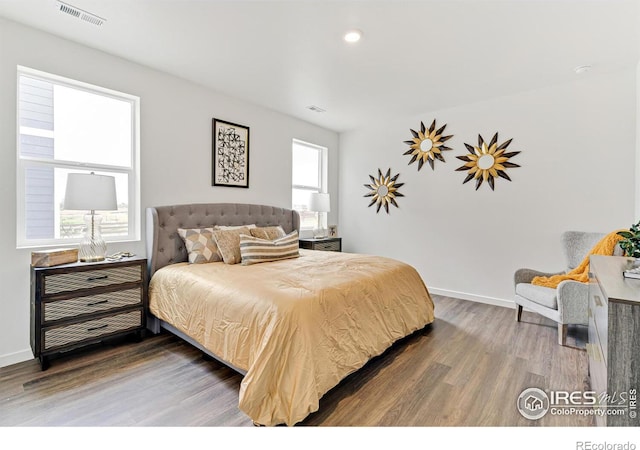 bedroom featuring dark wood finished floors, visible vents, and baseboards