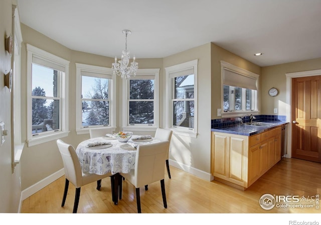 dining room featuring light wood-type flooring, recessed lighting, baseboards, and an inviting chandelier