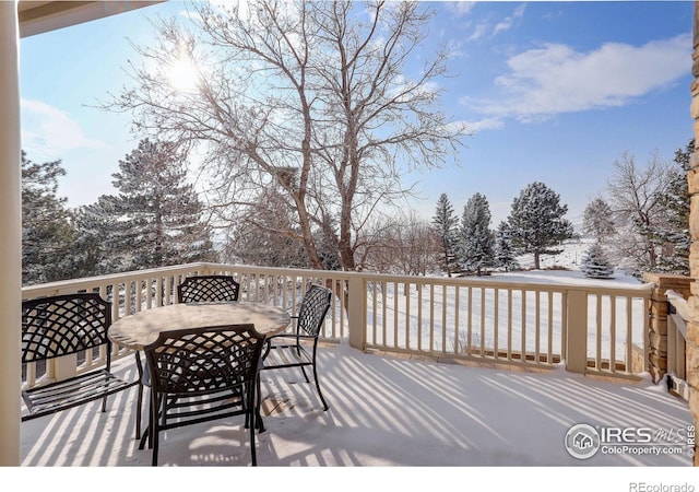 snow covered deck with outdoor dining space