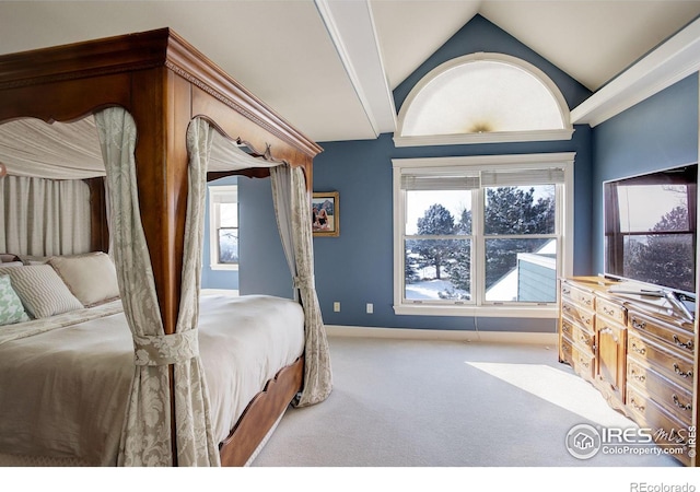 bedroom with lofted ceiling, baseboards, and light colored carpet