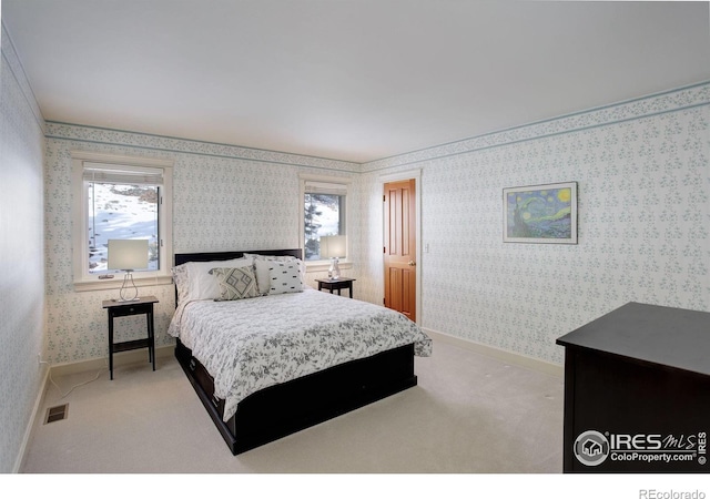 bedroom featuring light carpet, wallpapered walls, visible vents, and baseboards