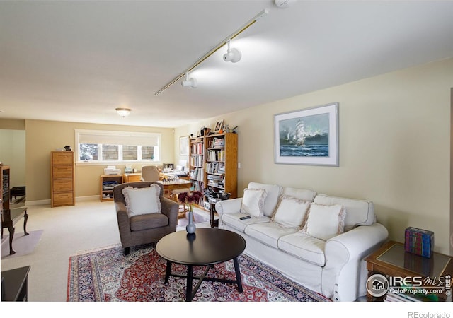 living room featuring rail lighting, light carpet, and baseboards