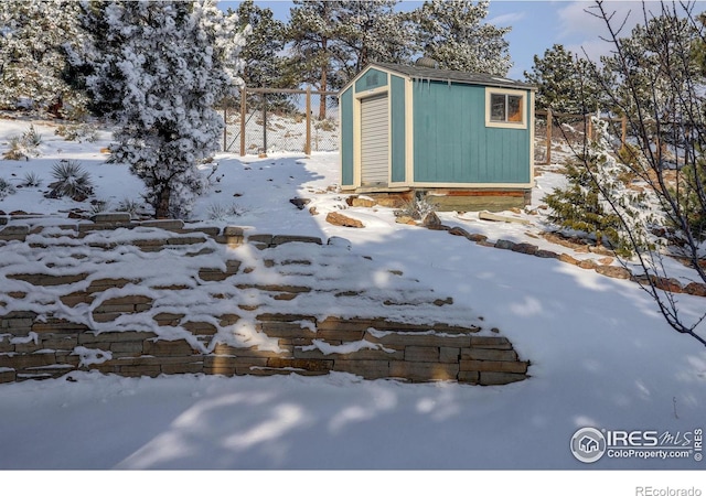 yard layered in snow with an outdoor structure and a storage shed