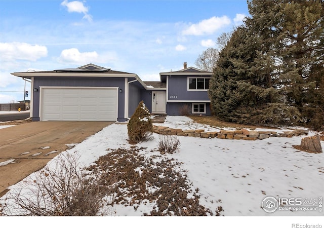 split level home featuring an attached garage and concrete driveway