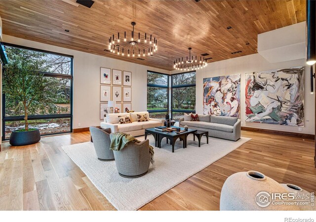 living area featuring wood ceiling, a healthy amount of sunlight, a notable chandelier, and wood finished floors