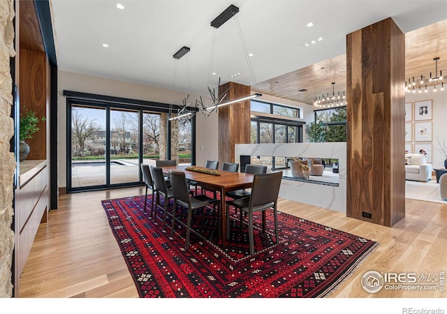 dining space featuring light wood-type flooring, plenty of natural light, an inviting chandelier, and recessed lighting