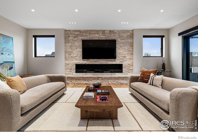 living area featuring recessed lighting, a fireplace, and light wood-style floors