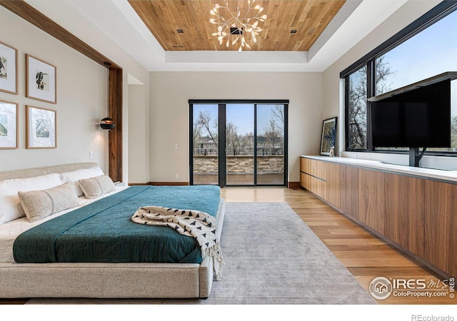 bedroom with wooden ceiling, access to exterior, a tray ceiling, light wood-style floors, and a notable chandelier