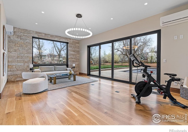 living room with light wood-type flooring and a wall mounted air conditioner