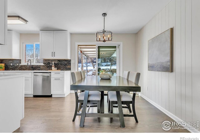 dining room featuring an inviting chandelier, light wood-style flooring, and baseboards