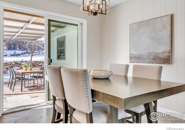 dining space with a chandelier and wood finished floors