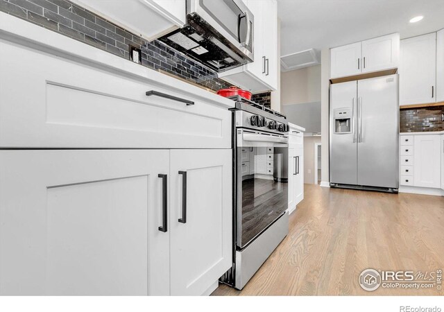 kitchen with recessed lighting, stainless steel appliances, white cabinets, decorative backsplash, and light wood finished floors