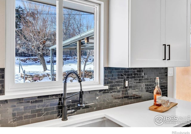 kitchen with decorative backsplash and white cabinets