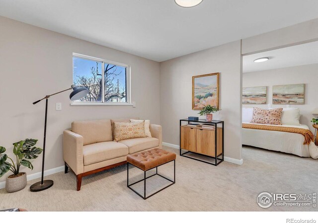 living room featuring light carpet and baseboards