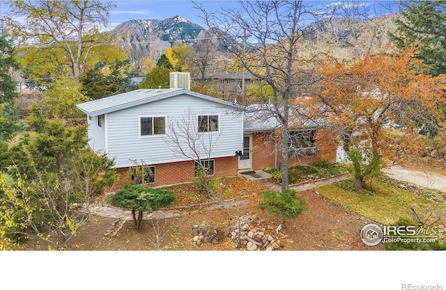 split level home featuring brick siding, a mountain view, and central air condition unit