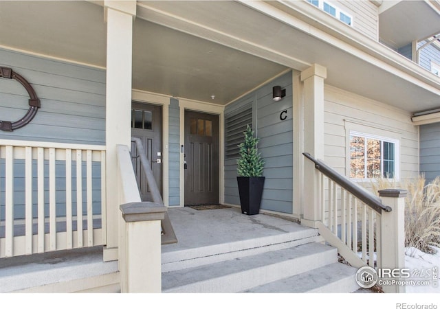 view of exterior entry featuring covered porch