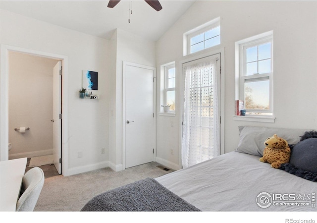 bedroom with ensuite bathroom, light colored carpet, visible vents, baseboards, and vaulted ceiling