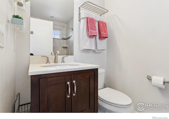 bathroom with toilet, walk in shower, and vanity