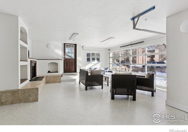 interior space with a fireplace with raised hearth, speckled floor, and a textured ceiling