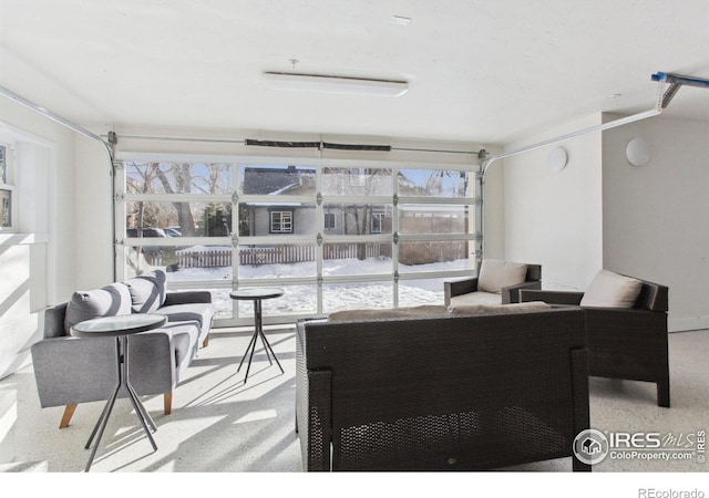 living room with a garage, light speckled floor, and a wealth of natural light