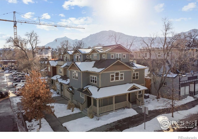 view of front of home with a residential view, a mountain view, and a porch