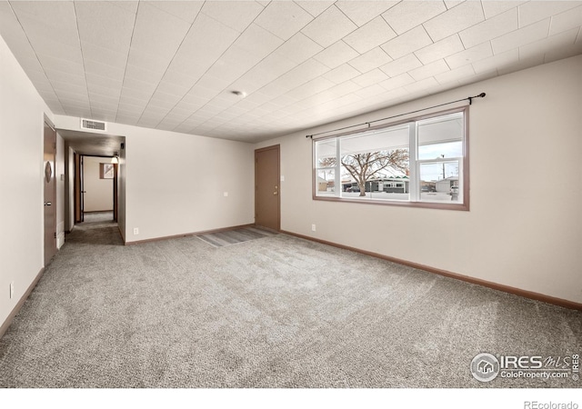 unfurnished room featuring baseboards, visible vents, and carpet flooring