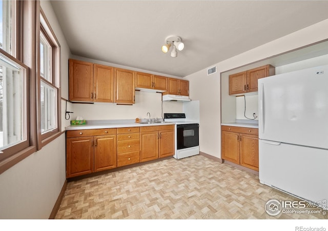 kitchen with white appliances, light countertops, a sink, and visible vents