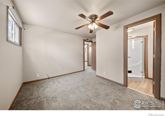 unfurnished bedroom with baseboards, ensuite bath, visible vents, and light colored carpet