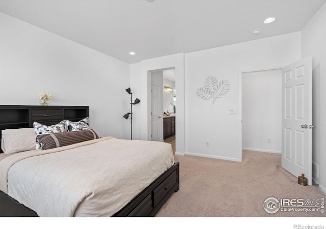 bedroom featuring baseboards, recessed lighting, ensuite bathroom, and light colored carpet