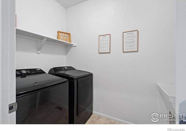 washroom featuring laundry area, washing machine and dryer, and baseboards