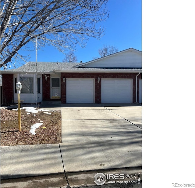 view of front of property with a garage, concrete driveway, and brick siding