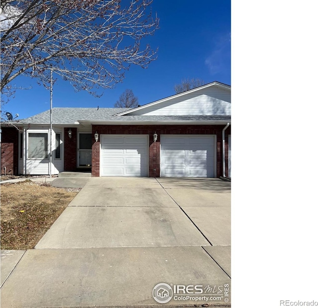 single story home with driveway, brick siding, an attached garage, and a shingled roof