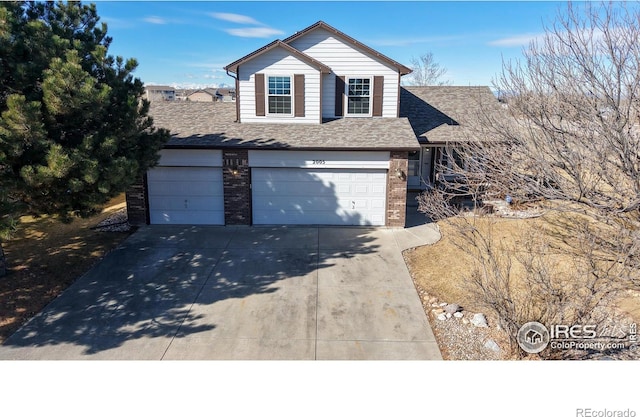 traditional home with an attached garage, a shingled roof, concrete driveway, and brick siding