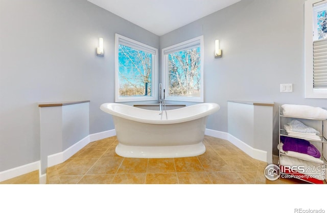 full bathroom featuring a soaking tub, tile patterned flooring, and baseboards