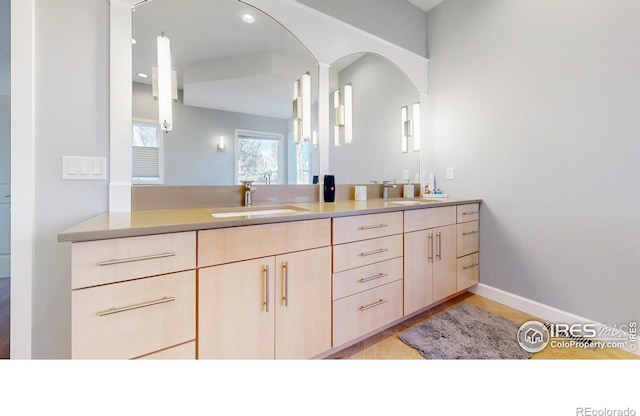 bathroom with recessed lighting, a sink, baseboards, and double vanity