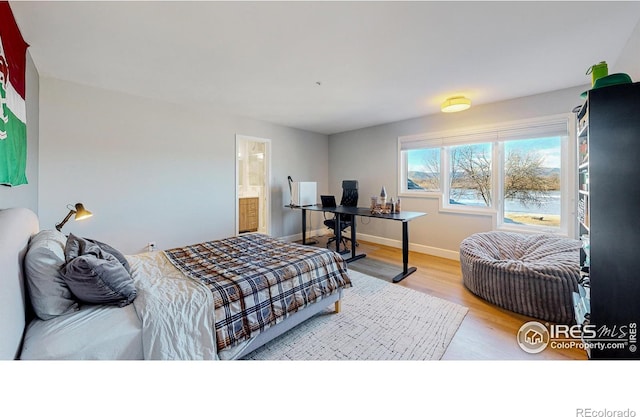 bedroom with baseboards and wood finished floors