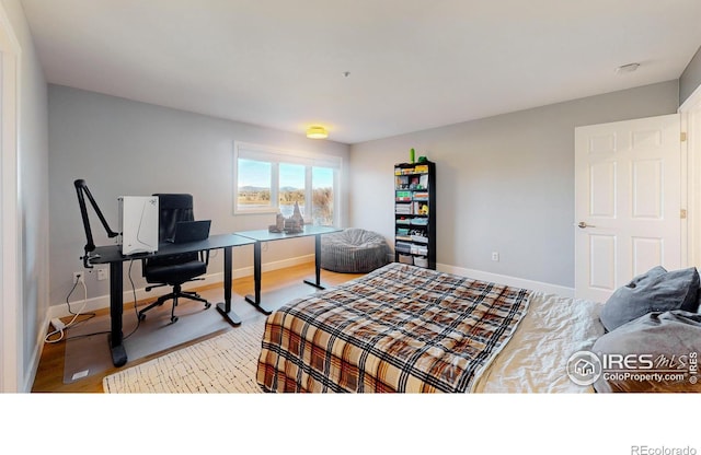 bedroom with baseboards and wood finished floors