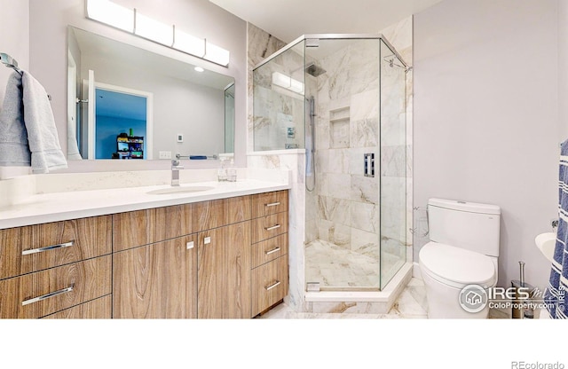 full bathroom featuring toilet, marble finish floor, a stall shower, and vanity