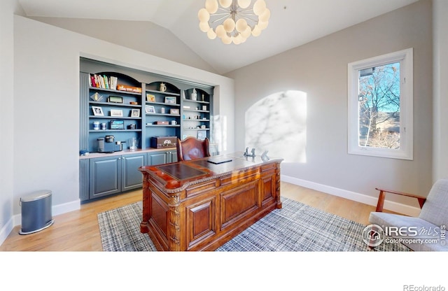 office space featuring lofted ceiling, a chandelier, light wood-style flooring, and baseboards