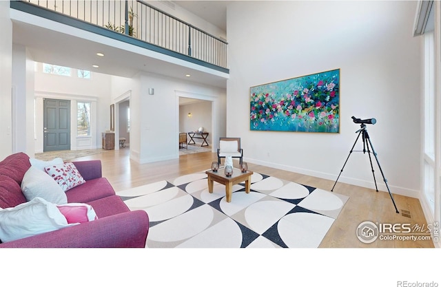 10667 E Goose Haven Dr, Lafayette, CO 80026 - living area with a towering ceiling, wood finished floors, and baseboards