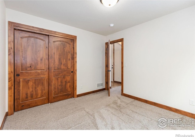 unfurnished bedroom with light carpet, visible vents, and baseboards