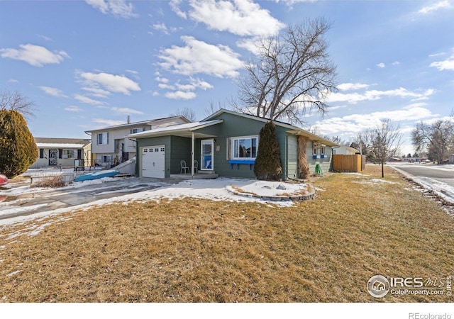 view of front of home featuring a front lawn, an attached garage, and fence